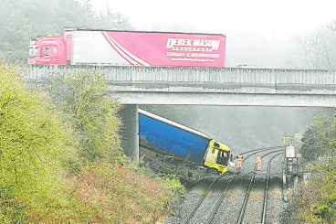 Railway closed after lorry crashes onto track